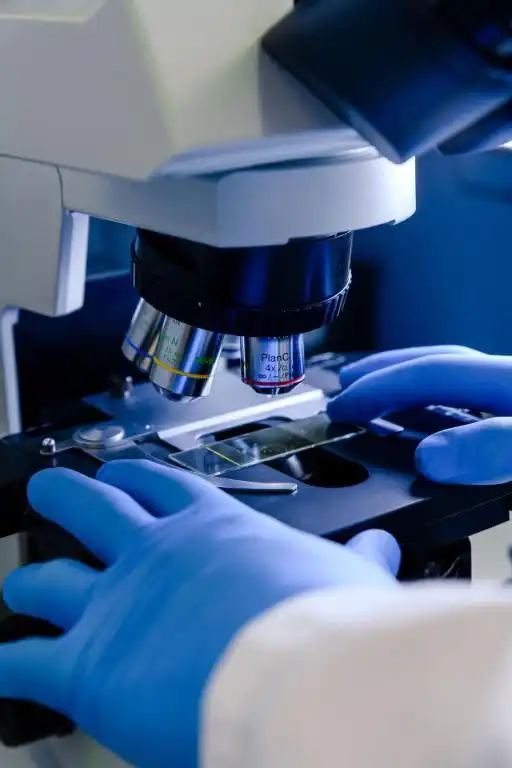 Laborantin d'a-ULaB analysant un échantillon au microscope dans le laboratoire de Gosselies